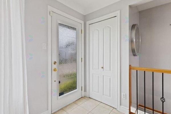 Interior entryway with a glass door, beige tile floor, and a closet. - 16 Rue Renaud, Gatineau