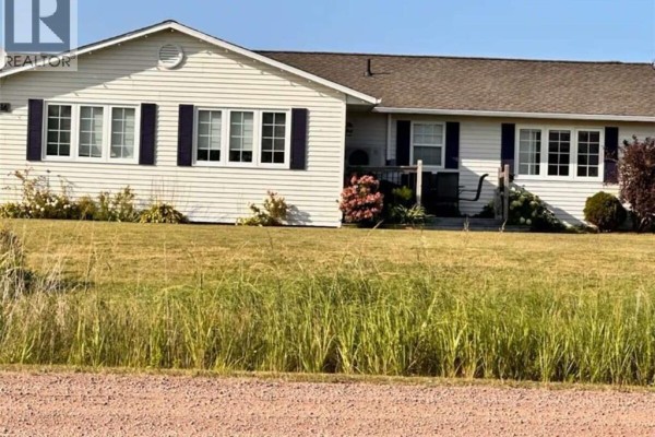 Exterior of a white bungalow with dark blue shutters and a green lawn. - 16 Spence's Beach Road, Murray Corner