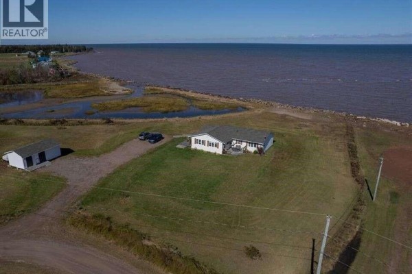 Aerial view of the property at 16 Spence's Beach Road with water and marshland. - 16 Spence's Beach Road, Murray Corner