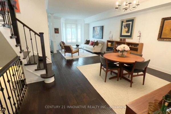 View of living and dining area from stairs, featuring dark wood floors and furniture. - 16 St Lawrence Drive, Mississauga