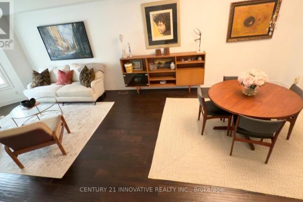 Living and dining area with modern furniture, wood floors, and wall art. - 16 St Lawrence Drive, Mississauga