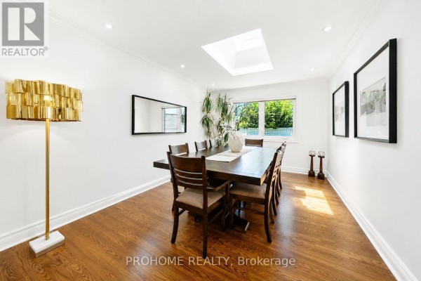 Dining room with large wooden table, skylight, and hardwood floors - 16 Tuscay Court Markham