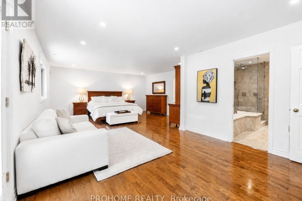 Primary bedroom with king bed, white sofa, and ensuite bath with tub and shower - 16 Tuscay Court Markham