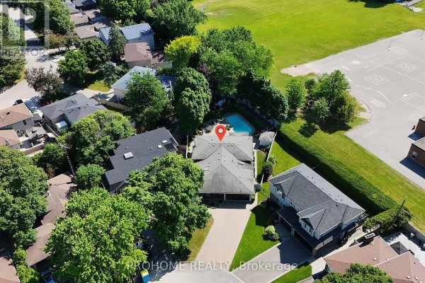Aerial view of a residential neighborhood showing houses, trees, and a school field. - 16 Tuscay Court, Markham