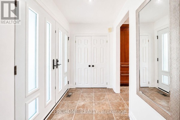 Bright entryway with double glass doors, double interior doors, and tiled flooring. - 16 Tuscay Court, Markham