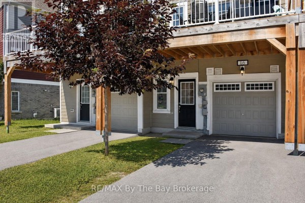 Ground level view of three garage doors and two entry doors on the rear of townhouses. - 16 Village Gate Drive, Wasaga Beach