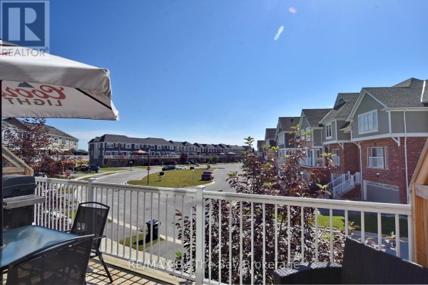 View from a townhouse deck overlooking a street lined with similar townhouses on a sunny day. - 16 Village Gate Drive, Wasaga Beach