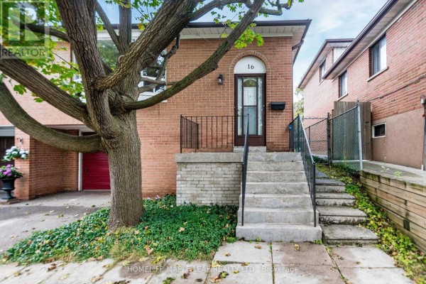 Front entrance stairs and doorway of a brick house with a black metal railing. - 16 Zealand Road, Toronto