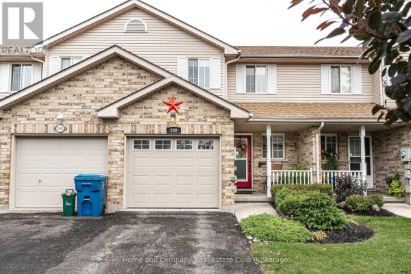 Front exterior of a townhouse with two garages and red front door. - 160 Athlone Crescent, Stratford