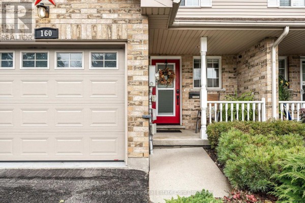 Close-up of townhouse entrance with red door and garage. - 160 Athlone Crescent, Stratford