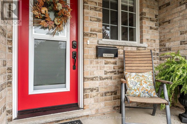 Red front door with fall wreath, chair, and mailbox on brick exterior. - 160 Athlone Crescent, Stratford