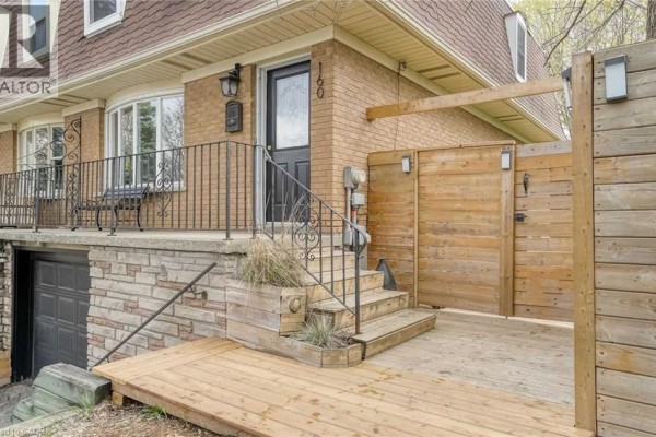 Close-up of the front entrance to a brick townhouse, featuring a wooden deck and gate. - 160 Breckenridge Drive Unit# Upper, Kitchener