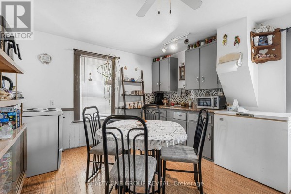Kitchen with dining table, pantry shelves, and exercise equipment - 160 Fares Street, Port Colborne