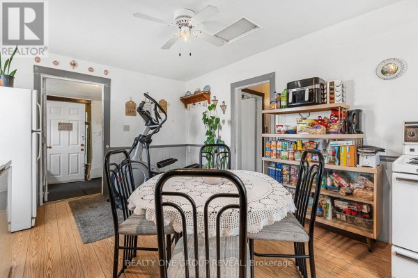 Bedroom featuring a large wall-mounted TV, dresser, and decorative art - 160 Fares Street, Port Colborne