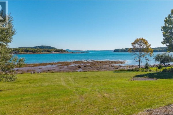 Expansive view of the water and surrounding trees from a grassy lawn at the property. - 160 Harkness Road, Chamcook