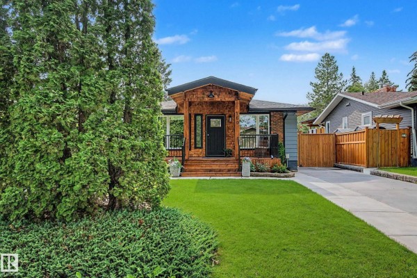 View of the house from the side with lush green trees in the foreground. - 160 Mission Av, St  Albert