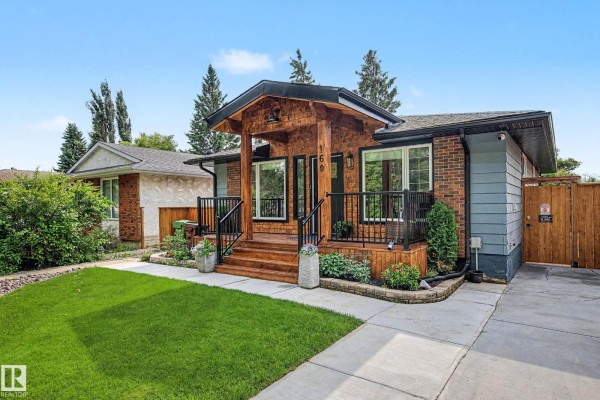 Close-up exterior view of the bungalow's entrance with wooden porch and steps. - 160 Mission Av, St  Albert