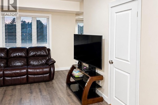 Living and dining area with a leather sofa, dining table, and stainless steel refrigerator. - 160 Rochefort Street Unit# C14, Kitchener