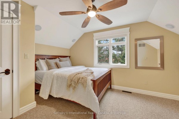 Bedroom with wooden bed, ceiling fan, and window - 160 Sunset Boulevard Blue Mountains