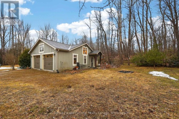 Two-car garage with covered porch and fire pit in wooded area - 160 Sunset Boulevard Blue Mountains