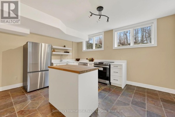 Kitchen with butcher block island, stainless steel appliances, and stone floors - 160 Sunset Boulevard Blue Mountains