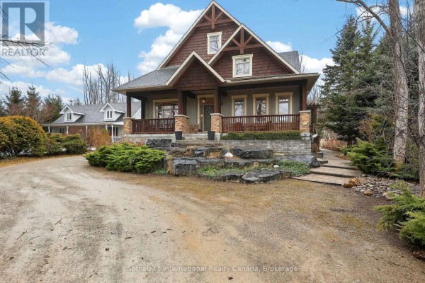 Mountain-style home with covered porch, stone accents, large boulders, and wood siding - 160 Sunset Boulevard Blue Mountains