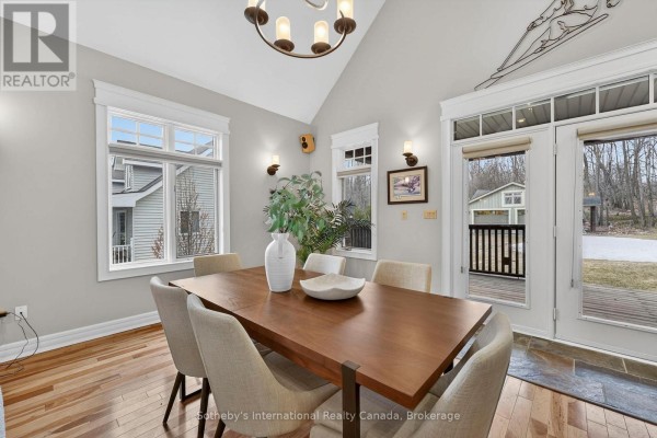Dining room with wood table, upholstered chairs, vaulted ceiling, chandelier, and exterior view - 160 Sunset Boulevard Blue Mountains