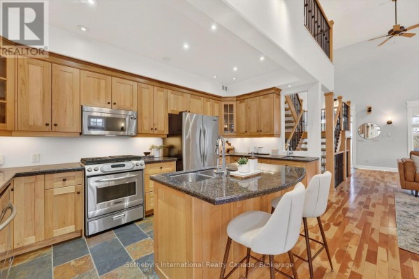 Modern kitchen with wood cabinets, SS appliances, island, and bar stools - 160 Sunset Boulevard Blue Mountains