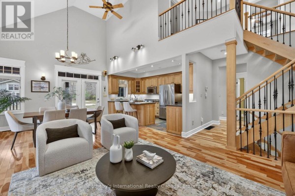 Living room with vaulted ceiling, modern chairs, and open staircase - 160 Sunset Boulevard Blue Mountains