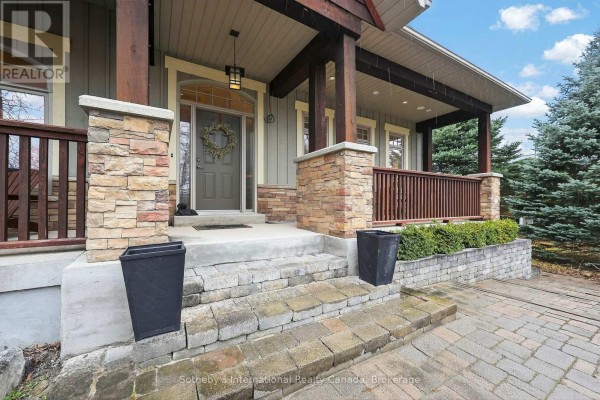 Covered porch with stone accents, wreath on door, and planters - 160 Sunset Boulevard Blue Mountains