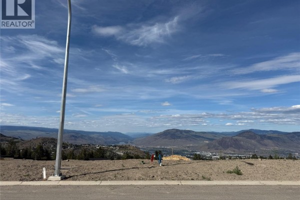 Bare land lot with a lamp post and utility marker, overlooking a scenic valley and mountains. - 1600 Aberdeen Drive Unit# 109, Kamloops