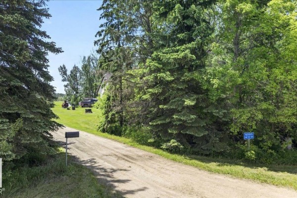 Gravel driveway leading to a mailbox and a house partially visible through trees. - 160005 Twp 540, Rural Lamont County