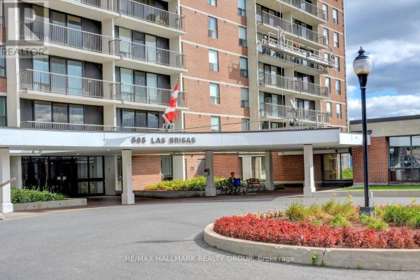 Entrance canopy with address 665 Las Brisas, brick exterior, and a circular flower bed. - 1601 - 665 Bathgate Drive, Ottawa