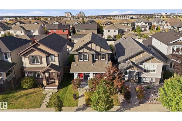 Aerial view of a suburban neighborhood with multiple houses and a distant cityscape. - 16012 11 Av Sw Sw, Edmonton