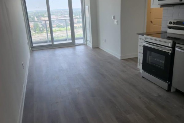 View of the living area and kitchen with large sliding glass doors. - 1602 - 1010 Sandy Beach Road, Pickering