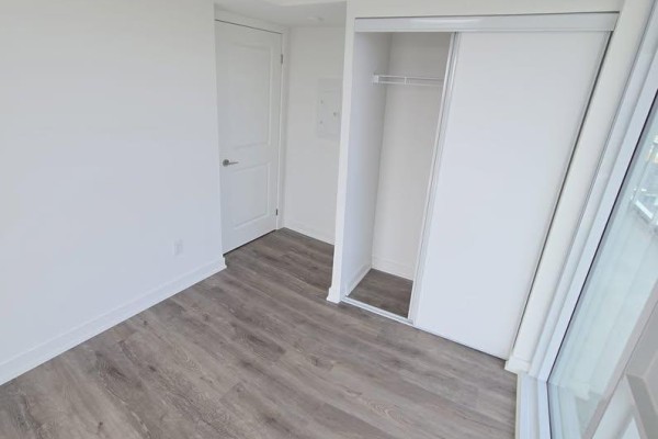 Closet with sliding doors and a white door in an empty room. - 1602 - 1010 Sandy Beach Road, Pickering