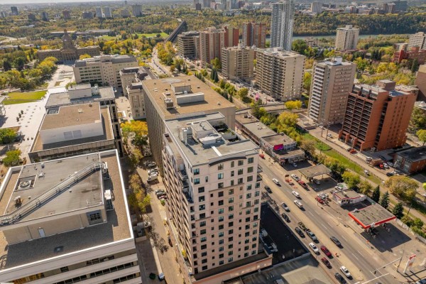 Aerial view of apartment buildings and city blocks with trees and blue sky. - #1603 9939 109 St Nw, Edmonton