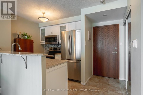 Kitchen with stainless steel appliances, granite countertops, and light cabinetry - 1604 - 10 Yonge Street, Toronto