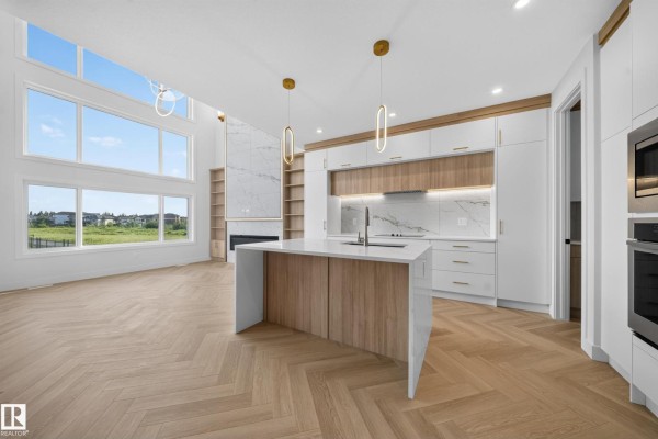 Open concept kitchen and living area with large windows and a view of the outdoors. - 1604 64 Ave Ne, Rural Leduc County