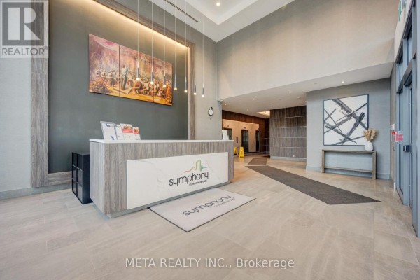 Building lobby featuring a reception desk, artwork, and elevator access. - 1605 - 15 Lynch Street, Brampton