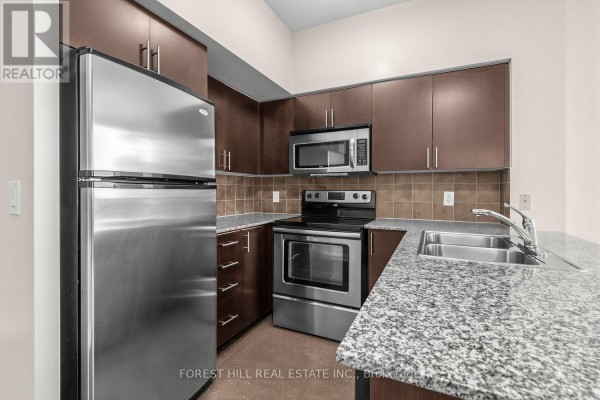 View of a kitchen with dark brown cabinets, granite countertops, and stainless steel appliances. - 1605 - 30 North Park Road, Vaughan