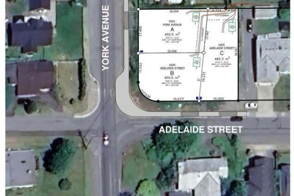 Grassy lot with a street, houses, trees, and a distant water view. - 1605 Adelaide St, Crofton