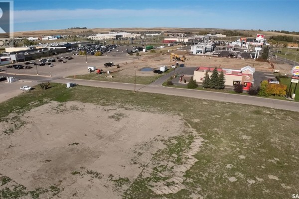 Aerial view of the cleared lot with businesses, including a Burger King, to the left and commercial buildings in the background. - 1605 North Service Road E, Swift Current