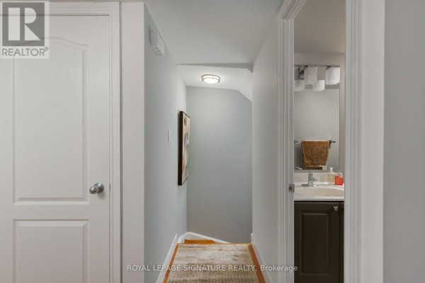 Interior hallway with closed doors, light blue walls, and a staircase leading down. - 1606 - 12 Sudbury Street, Toronto