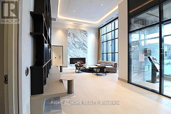 Spacious lobby with floor-to-ceiling windows and contemporary furniture. - 1606 - 130 River Street, Toronto