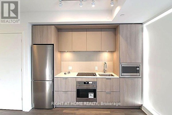 Compact kitchen with stainless steel appliances and light wood cabinetry. - 1606 - 130 River Street, Toronto