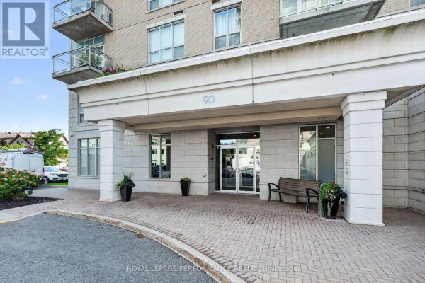 Entrance to apartment building 90 Landry Street with paved driveway and bench. - 1606 - 90 Landry Street, Ottawa