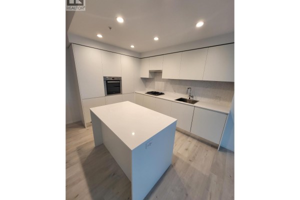 Contemporary kitchen featuring white cabinetry, island, stainless steel oven, and gas cooktop. - 1606 3809 Evergreen Place, Burnaby
