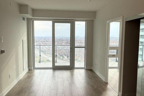 Living area with large windows and a sliding glass door overlooking a city view. - 1607 - 430 Square One Drive, Mississauga