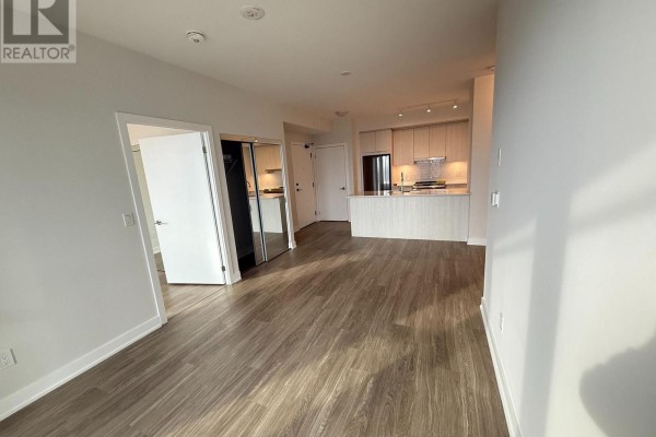 Open-concept living area with view of the kitchen, entryway, and mirrored closet doors. - 1607 - 430 Square One Drive, Mississauga